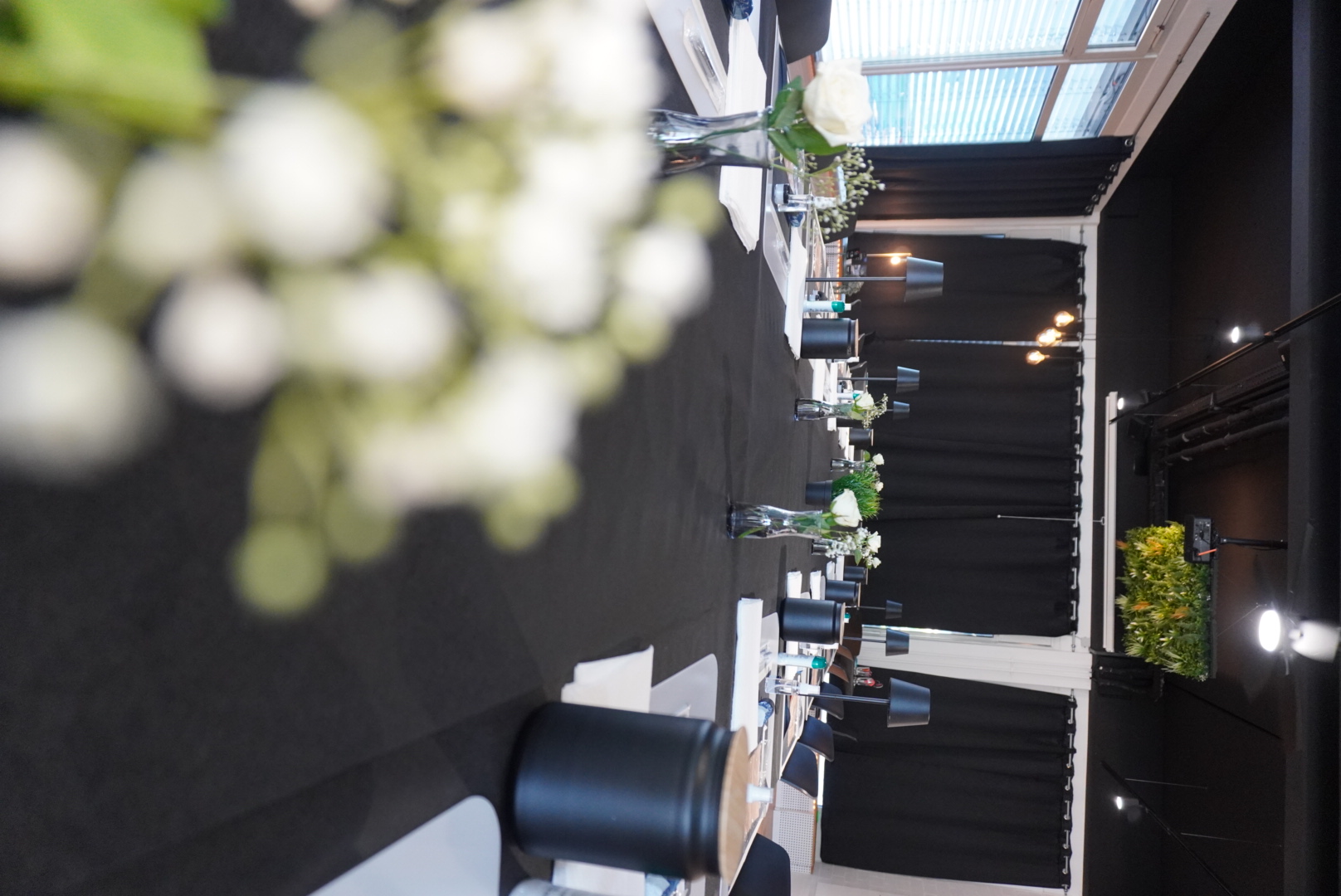 Der Location-Raum von INKVIBES – stimmungsvoll eingedeckt mit weißen Blumen und schwarzen Tischläufern